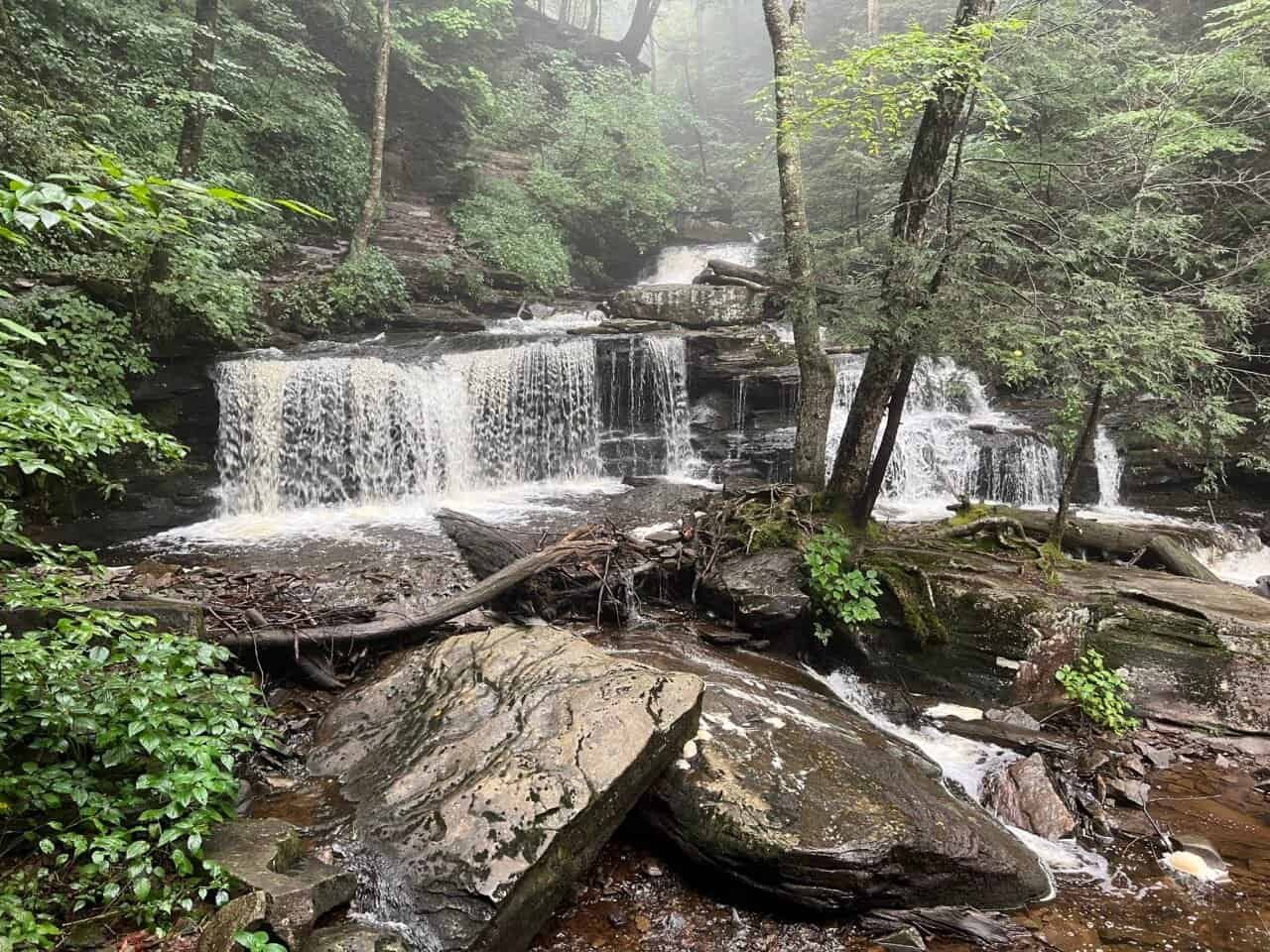 Misty waterfall cascading over layered rock formations along the Falls Trail at Ricketts Glen State Park in Pennsylvania