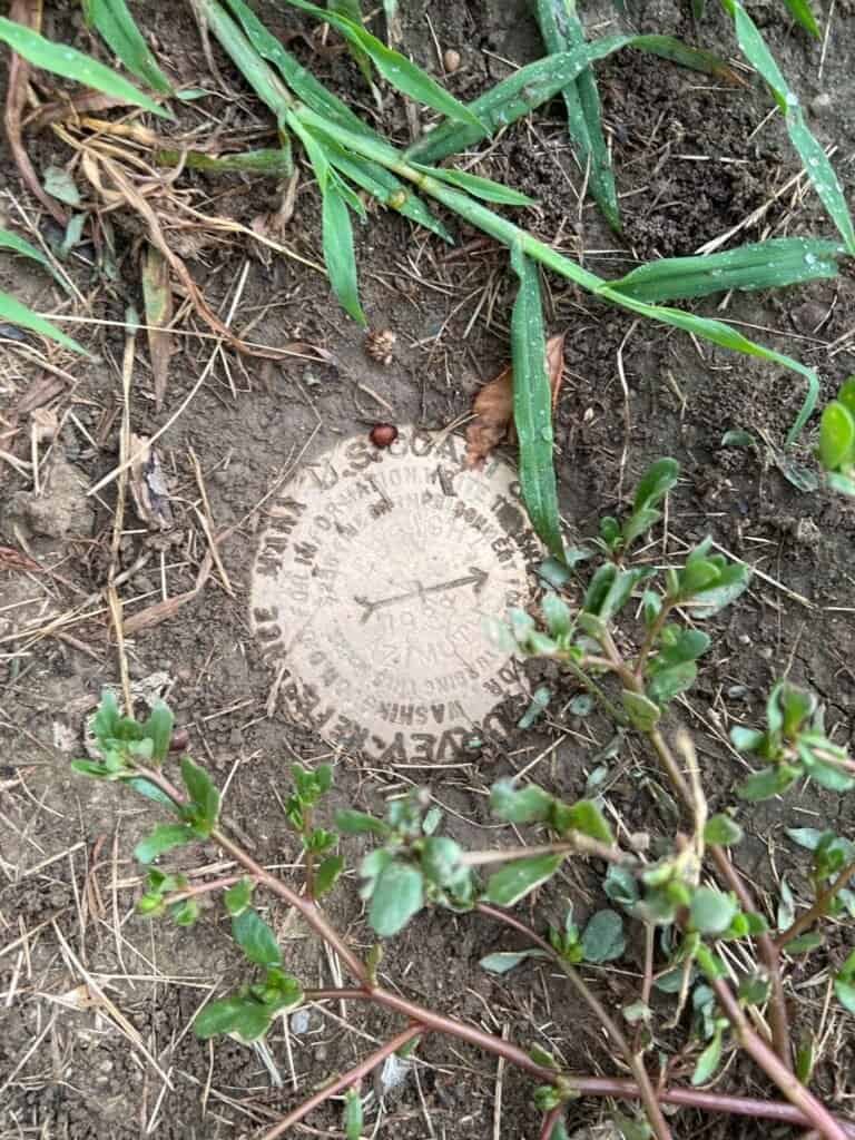 Survey benchmark disk marking Ebright Azimuth, Delaware’s highest point, set in the ground
