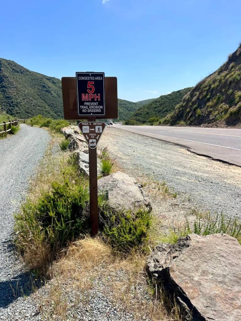 Trail signage along Del Dios Gorge showing a 5 mph speed limit where the trail runs parallel to the highway.