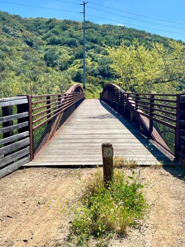 Del Dios Bridge on the Lake Hodges trail, spanning a green canyon with rolling hills in the background