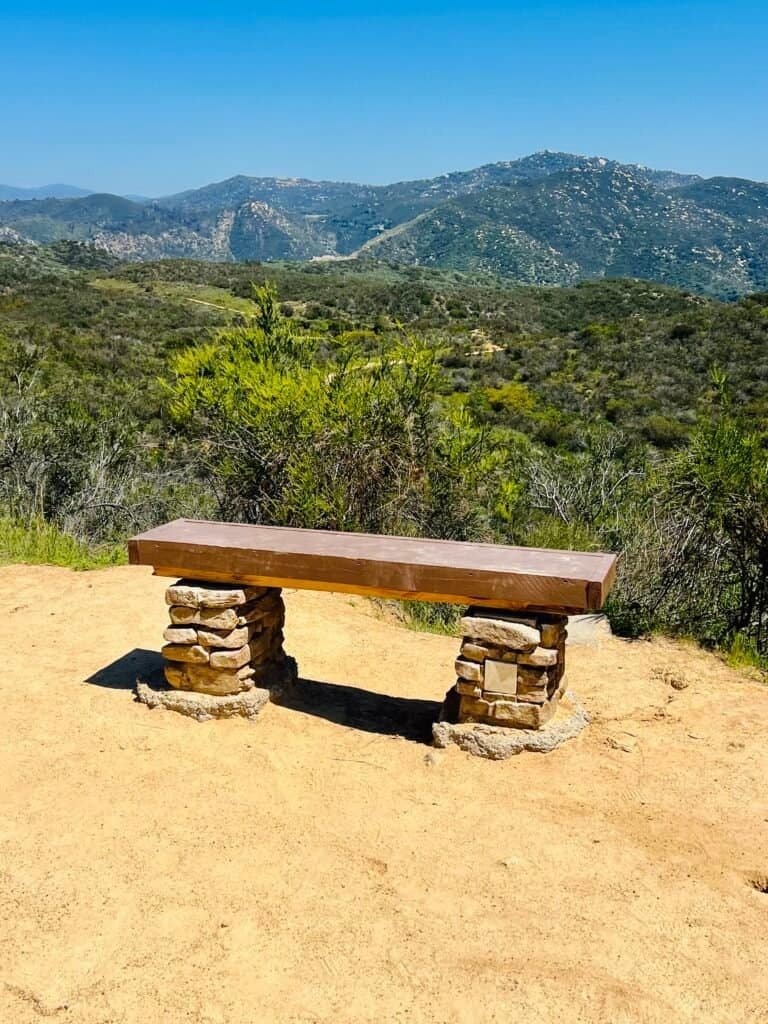 Stone bench overlooking rolling hills and chaparral landscape at Daley Ranch in Escondido, California.