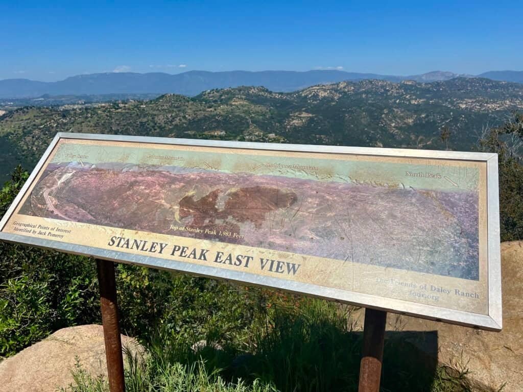 Interpretive sign labeled “Stanley Peak East View” overlooking rolling hills and distant mountain ranges at Daley Ranch in Escondido, California.