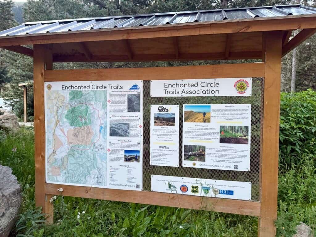 Enchanted Circle Trails information kiosk with trail map and signage near the Wheeler Peak trailhead in northern New Mexico.
