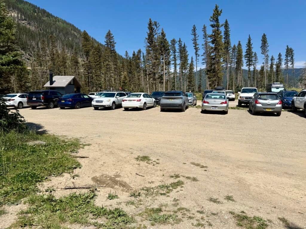 Crowded trailhead parking lot filled with cars after a busy hiking day near Wheeler Peak in northern New Mexico.