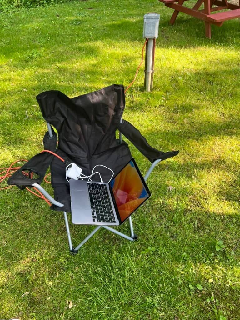 Laptop set up on a camp chair with a power hookup at Wolfie’s Campground, serving as a mobile office