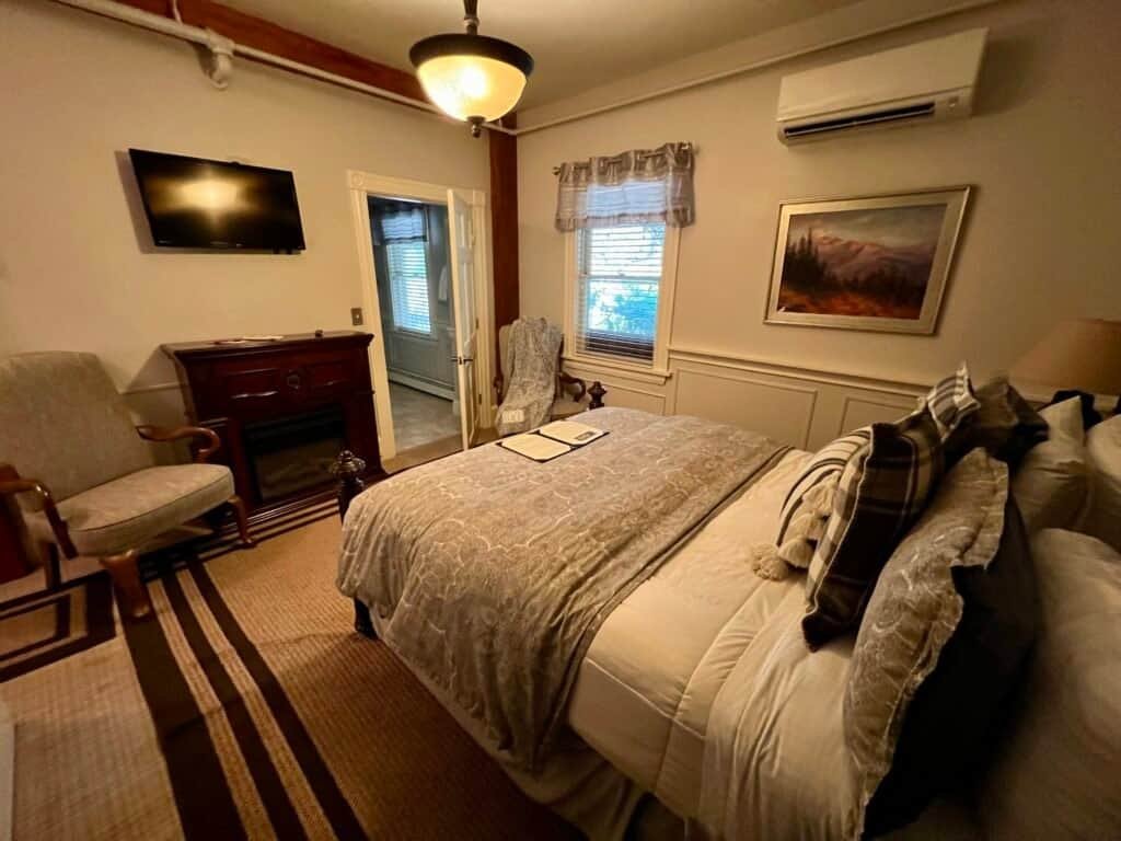 Guest room at the Bernerhof Inn in Glen, New Hampshire, with a queen bed, seating area, and classic New England décor.