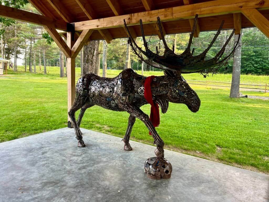 Metal moose sculpture made from gears and scrap metal under a pavilion at Ledge Brewing Company in Intervale, New Hampshire.