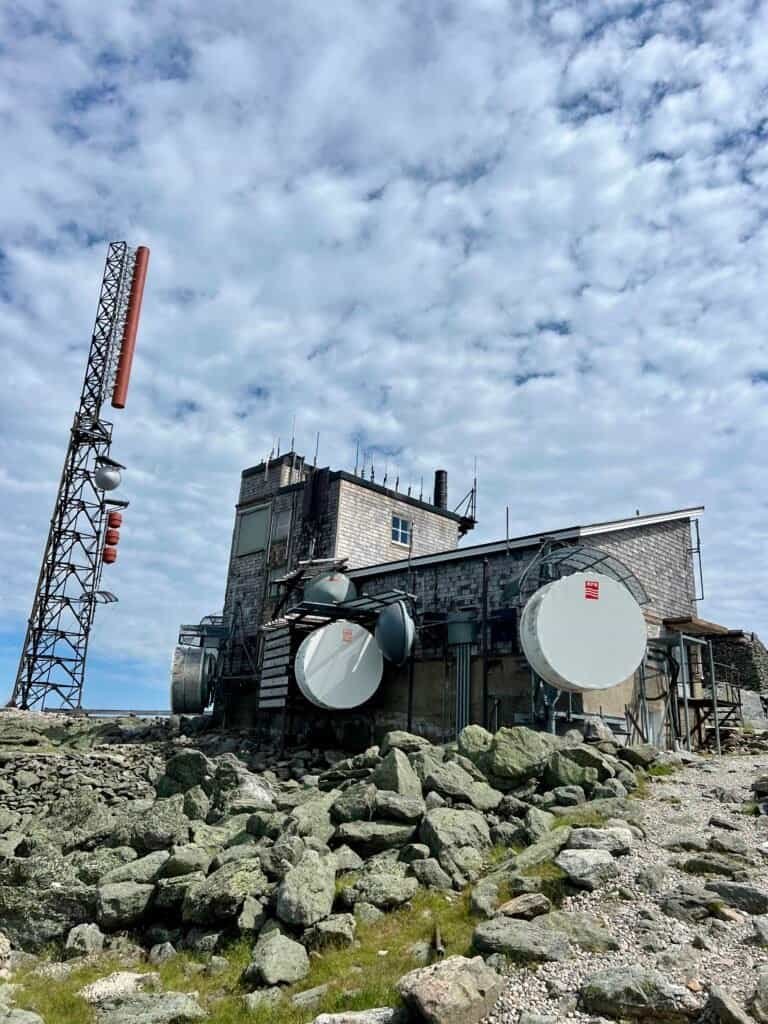 Mount Washington summit observatory and communications building surrounded by rocky alpine terrain.