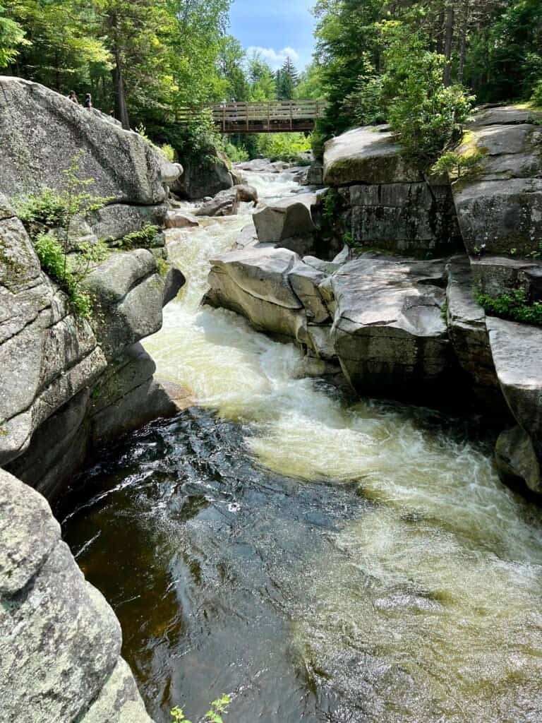 Ammonoosuc River flowing through a rocky gorge beneath a wooden footbridge in New Hampshire