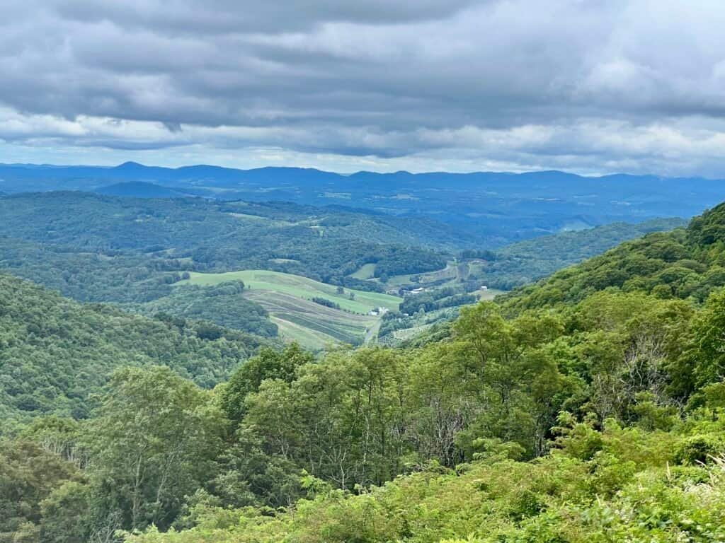 Rolling Blue Ridge Mountain valley with layered green hills under dramatic clouds