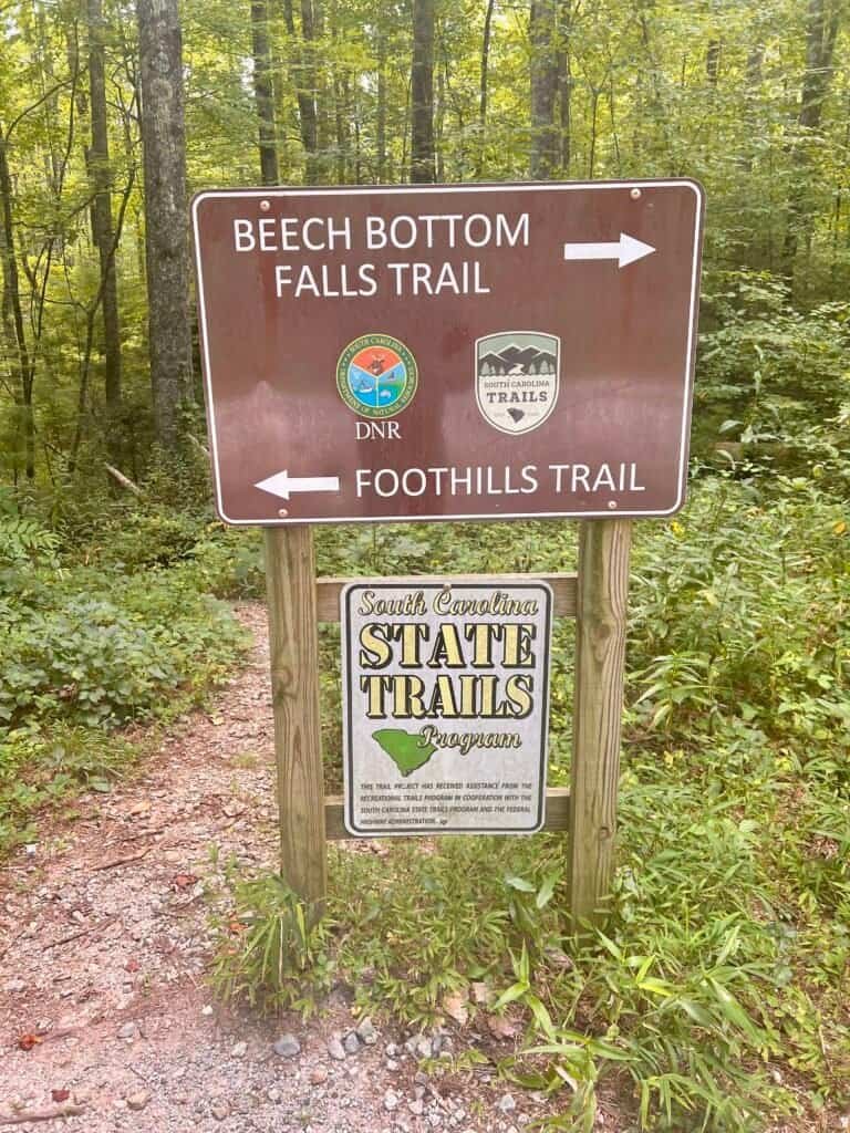 Trail sign at the Sassafras Mountain parking lot showing directions to Beech Bottom Falls and the Foothills Trail