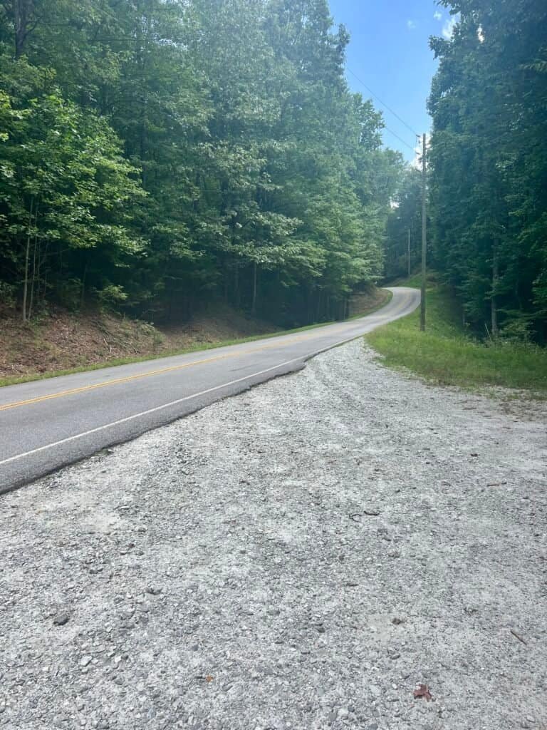 View up Sassafras Mountain Road from the lower parking lot where hikers walk uphill to reach the Foothills Trail