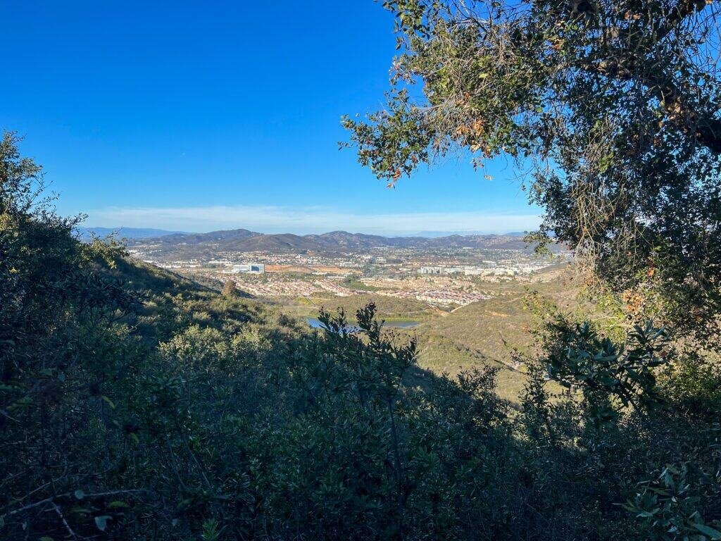 Lakeview Trail near the trailhead at Double Peak Park with hillside vegetation and views toward South Lake and San Marcos below