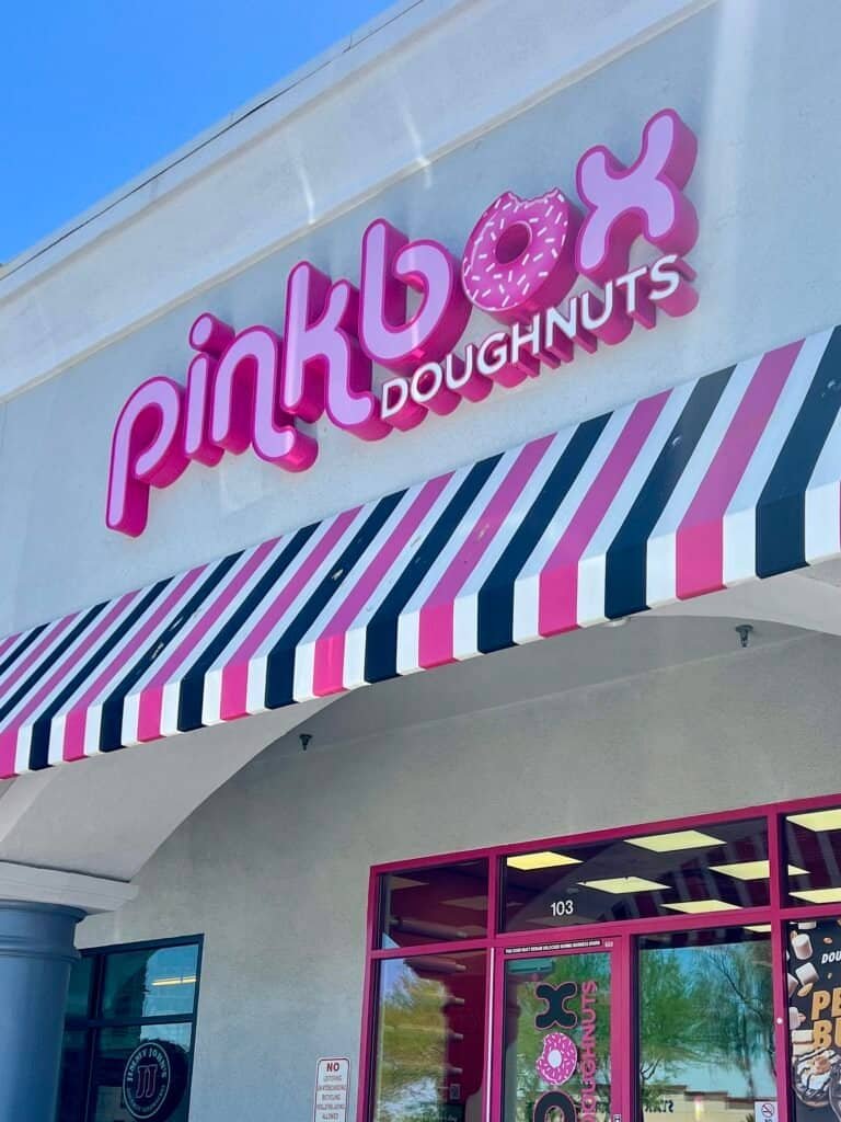 Pinkbox Doughnuts storefront in Las Vegas with bright pink signage and striped awning.