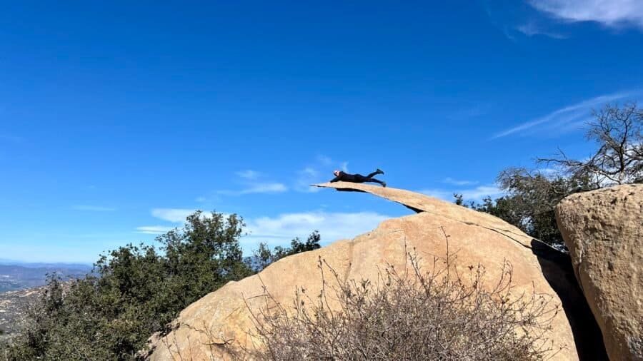 Hiker lying on Potato Chip Rock on Mount Woodson in Poway, California