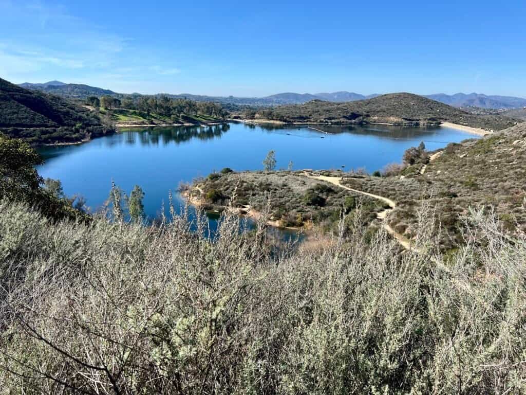 View of Lake Poway from the trail with surrounding hills in Poway, California