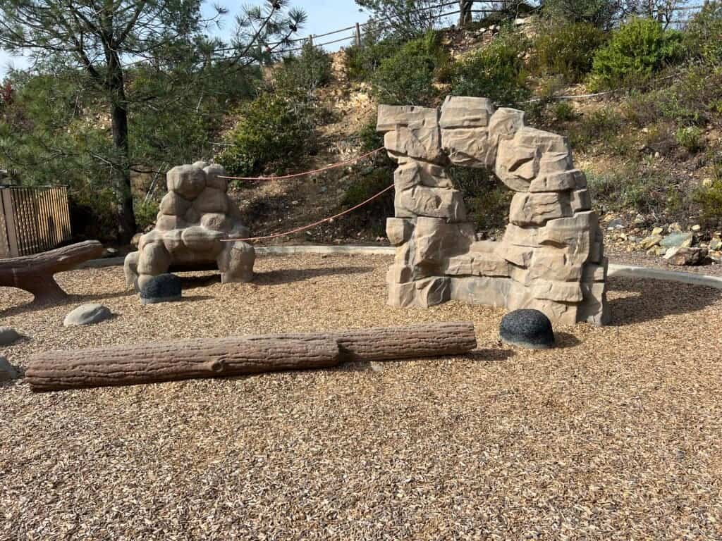 Playground area at Double Peak Park in San Marcos, California, with climbing structures and natural play features near the summit