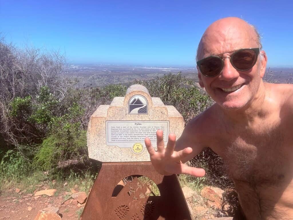 Hiker at the Pyles Peak summit marker at Mission Trails Regional Park
