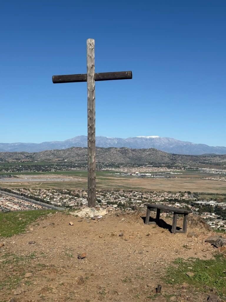 View from the third summit looking out over surrounding neighborhoods, green hills, and distant mountains under a clear blue sky