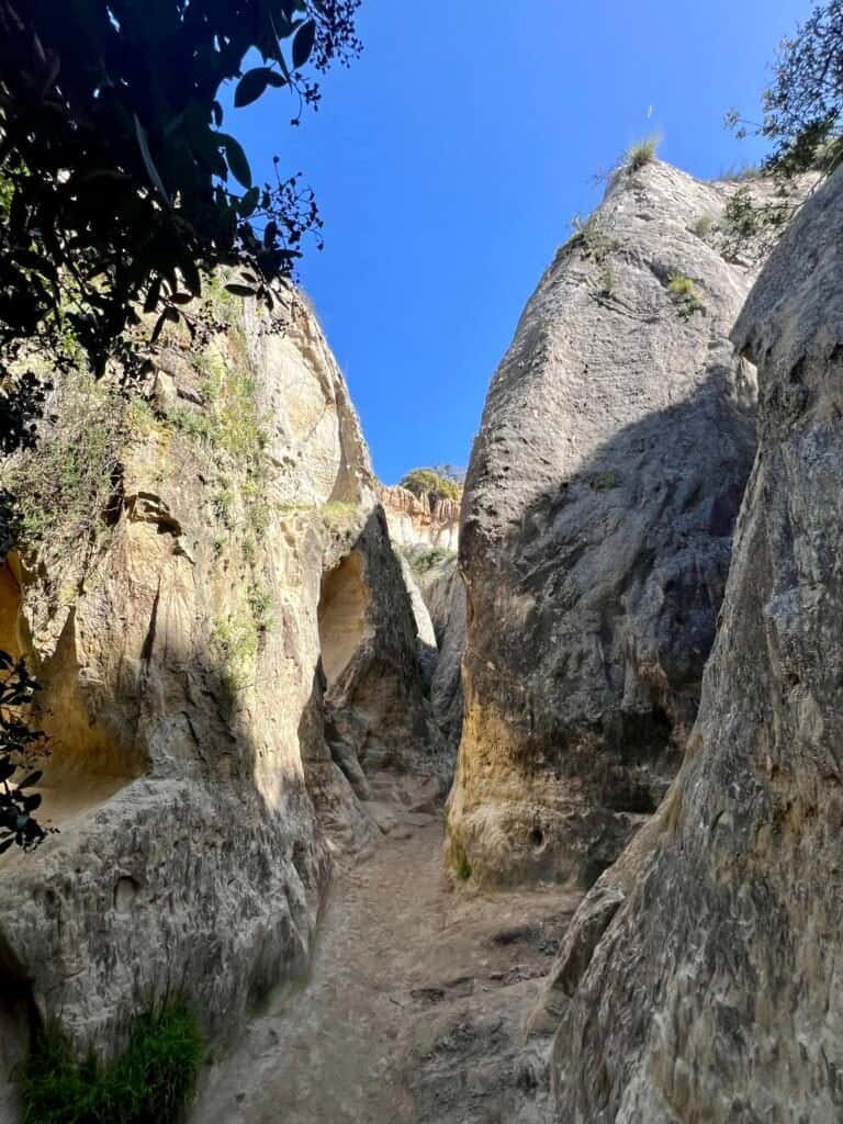 Narrow sandstone corridor inside Annie’s Canyon with steep walls and filtered sunlight
