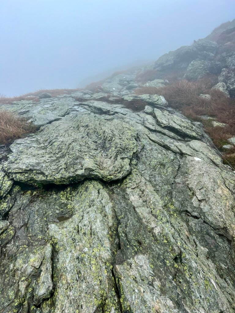 Steep, fog-covered granite ridge along the Long Trail leading toward the Mount Mansfield summit.