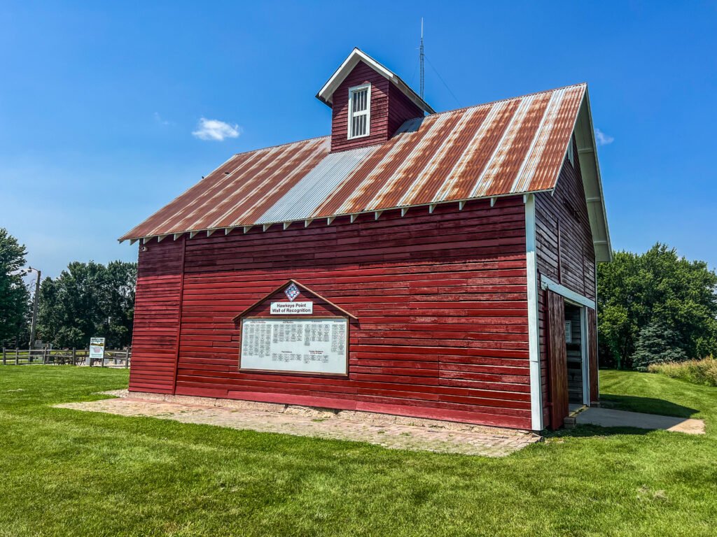 Red barn-style walk-through museum building at Hawkeye Point featuring the Wall of Recognition display.