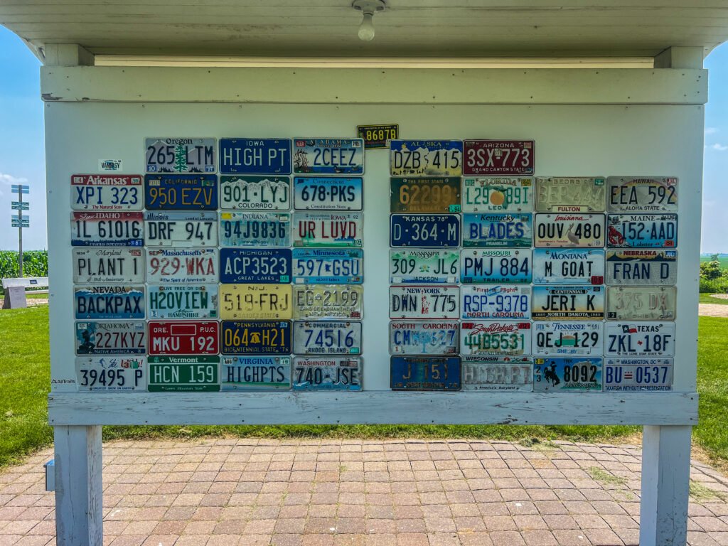 Display board of U.S. state license plates from highpointers mounted at Hawkeye Point in Iowa.