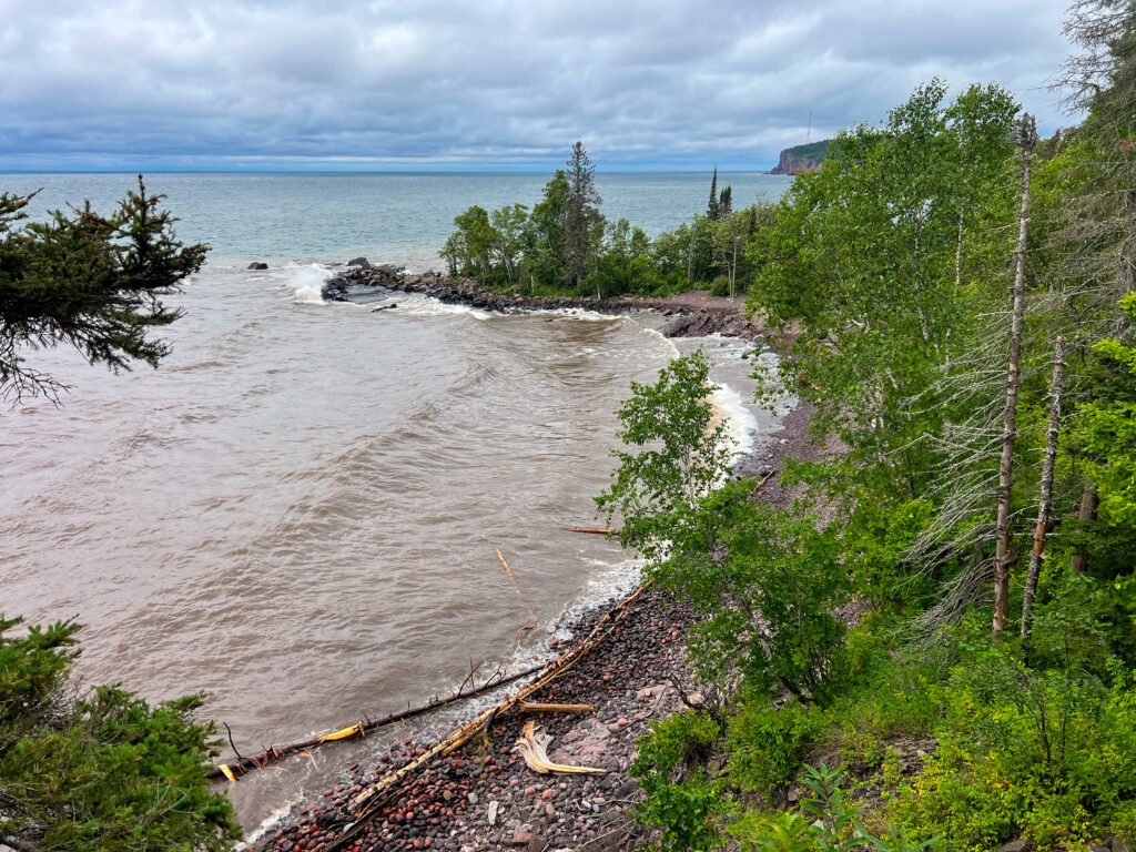 Overlook view of Lake Superior Beach with driftwood scattered along the shoreline at Tettegouche State Park.