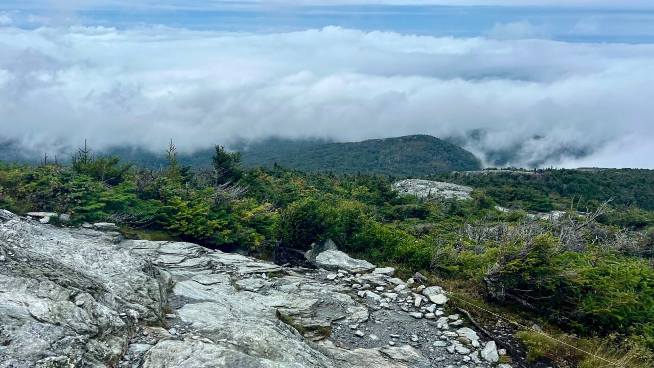 Rocky alpine ridge on Mount Mansfield with low clouds rolling over the Green Mountains in Vermont.