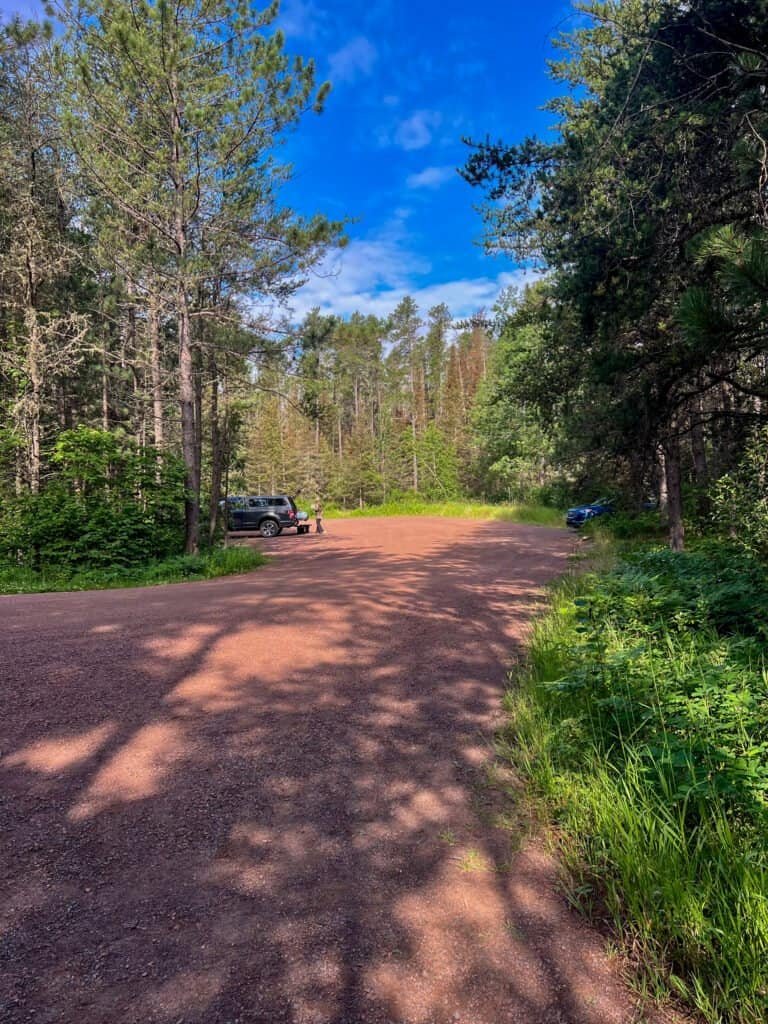 Small gravel parking area at the Eagle Mountain trailhead surrounded by trees in the Boundary Waters region of Minnesota.