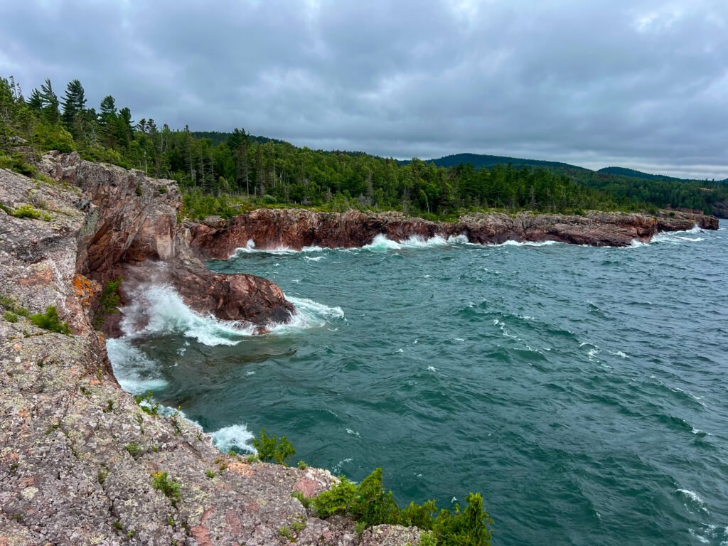 Waves crashing against the rugged cliffs of Lake Superior at Tettegouche State Park.