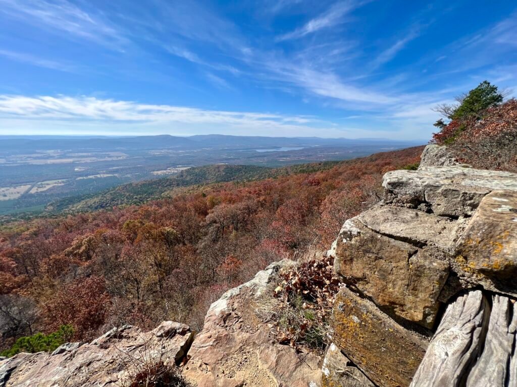 View from Mount Magazine overlooking fall foliage and Blue Mountain Lake in the distance.