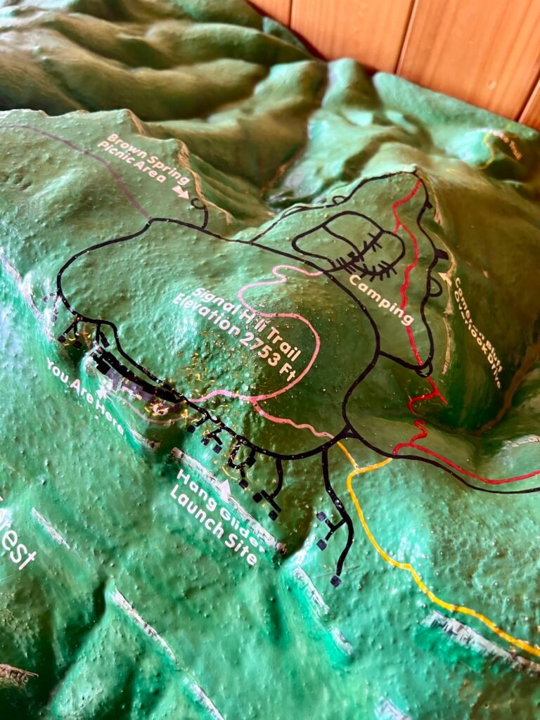 3D topographic model of Mount Magazine area inside the lodge, showing trails, campground, and Signal Hill elevation markers.