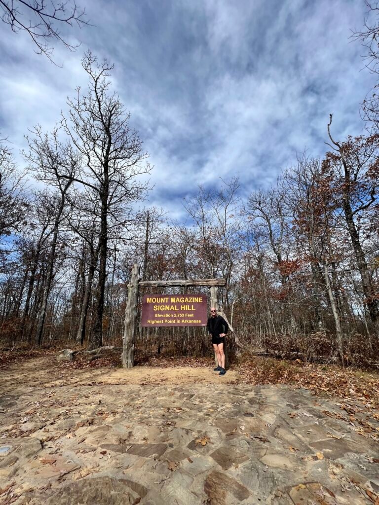 Stephen standing beside the Mount Magazine Signal Hill summit sign, Arkansas high point.