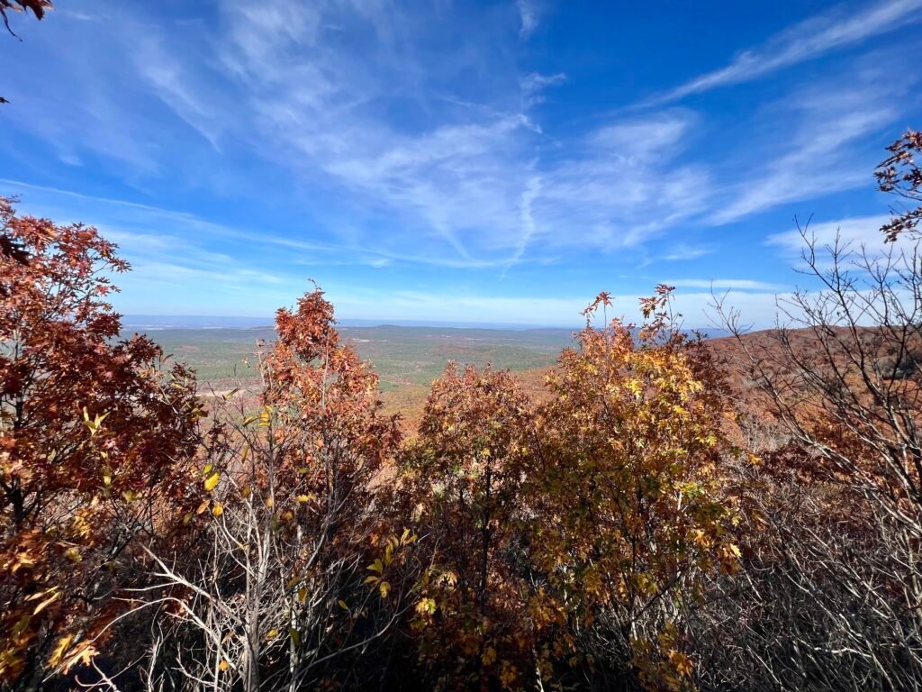 Autumn view from Dill Point overlooking the Ouachita Mountains with colorful fall foliage in the foreground.