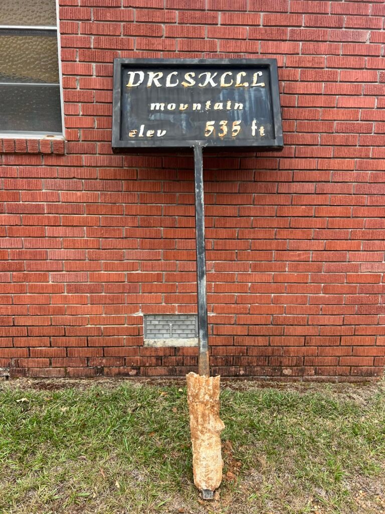Black Driskill Mountain elevation sign reading 535 ft displayed against red brick wall of Mt. Zion Presbyterian Church