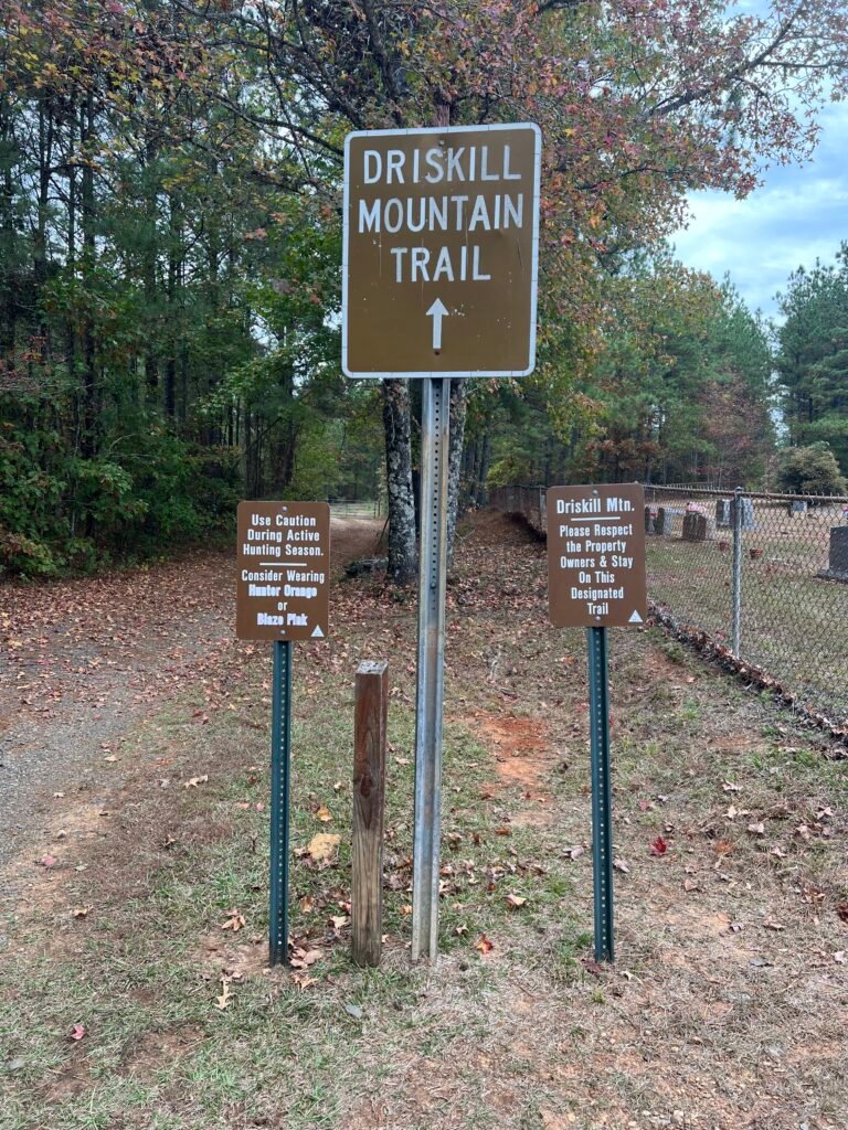 Driskill Mountain Trail sign at Mt. Zion Presbyterian Church with hunting season warnings and designated trail notices.
