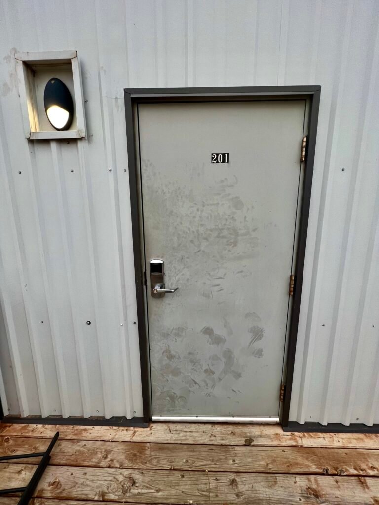 Exterior door to a modular hotel room at Karbani Inn in Carlsbad, New Mexico.