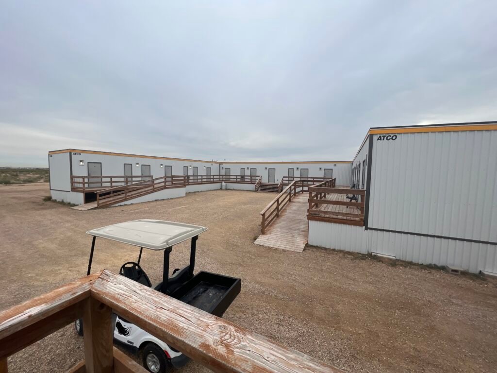 Modular-style Karbani Inn lodging units with wooden walkways in Carlsbad, New Mexico.
