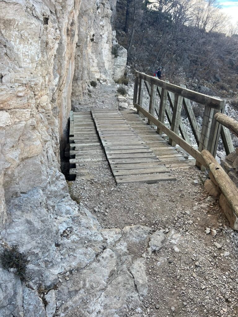 Close-up view of wooden footbridge anchored into limestone cliff along the Guadalupe Peak Trail.