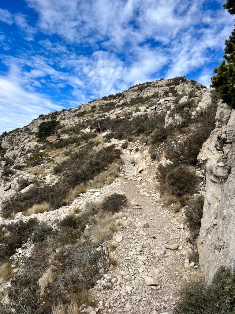Rocky switchback trail on Guadalupe Peak with hiker in the distance nearing the summit
