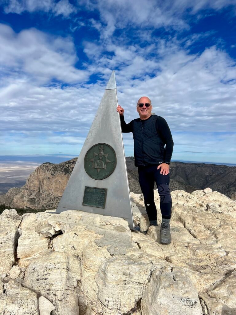 Standing at the Guadalupe Peak summit monument, marking High Point #27