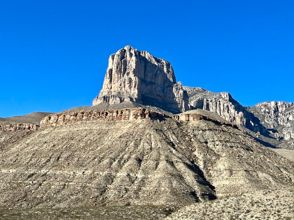 El Capitan’s sheer limestone face rising above layered desert hills beneath a deep blue Texas sky