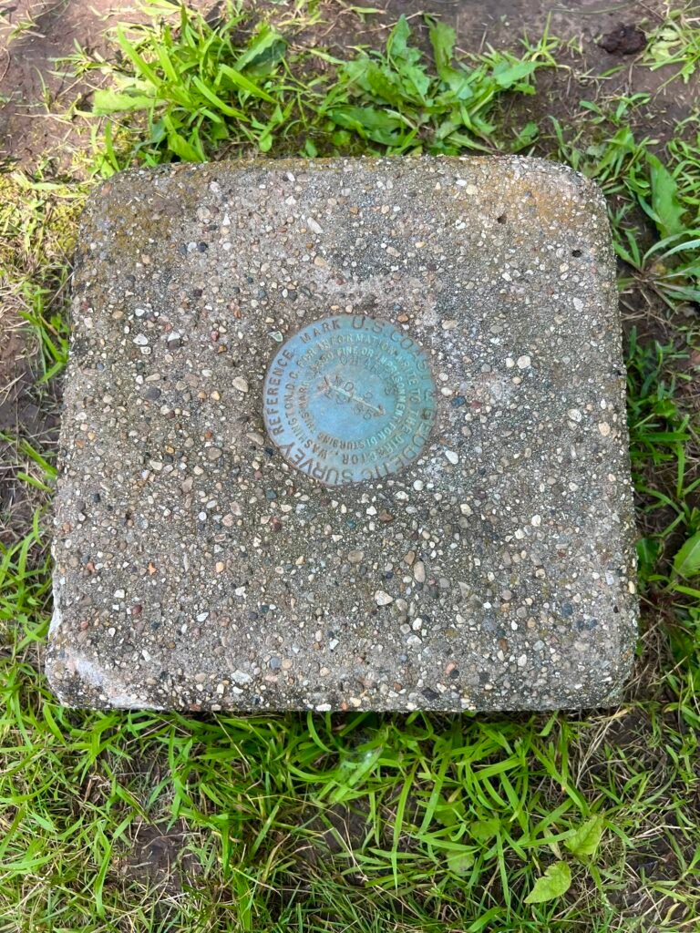USGS survey marker embedded in concrete marking the highest natural point in Illinois at Charles Mound.