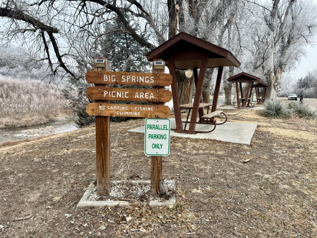 Big Springs Picnic Area sign and covered picnic shelters at Lake Scott State Park.