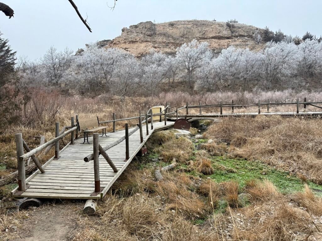 Wooden footbridge crossing a small creek near Big Springs at Lake Scott State Park in winter.
