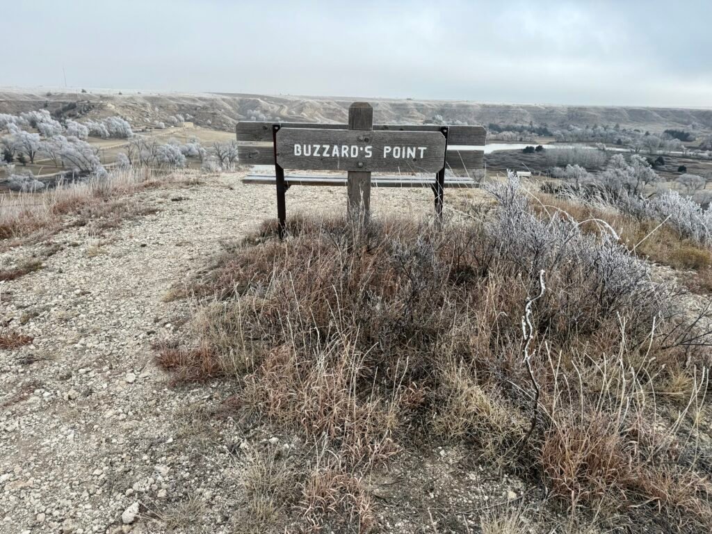 Buzzard’s Point sign overlooking Historic Lake Scott State Park and the frosty valley below