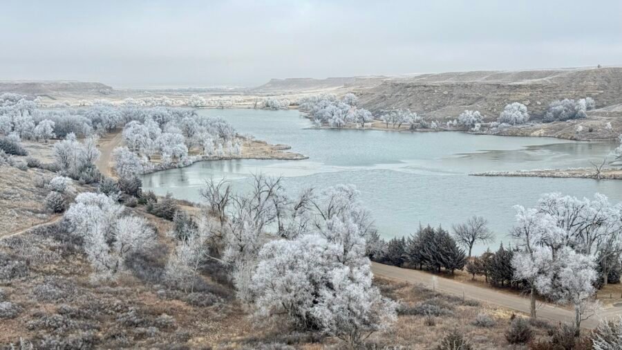 Winter view of Historic Lake Scott in western Kansas with frost-covered trees and partially frozen lake.