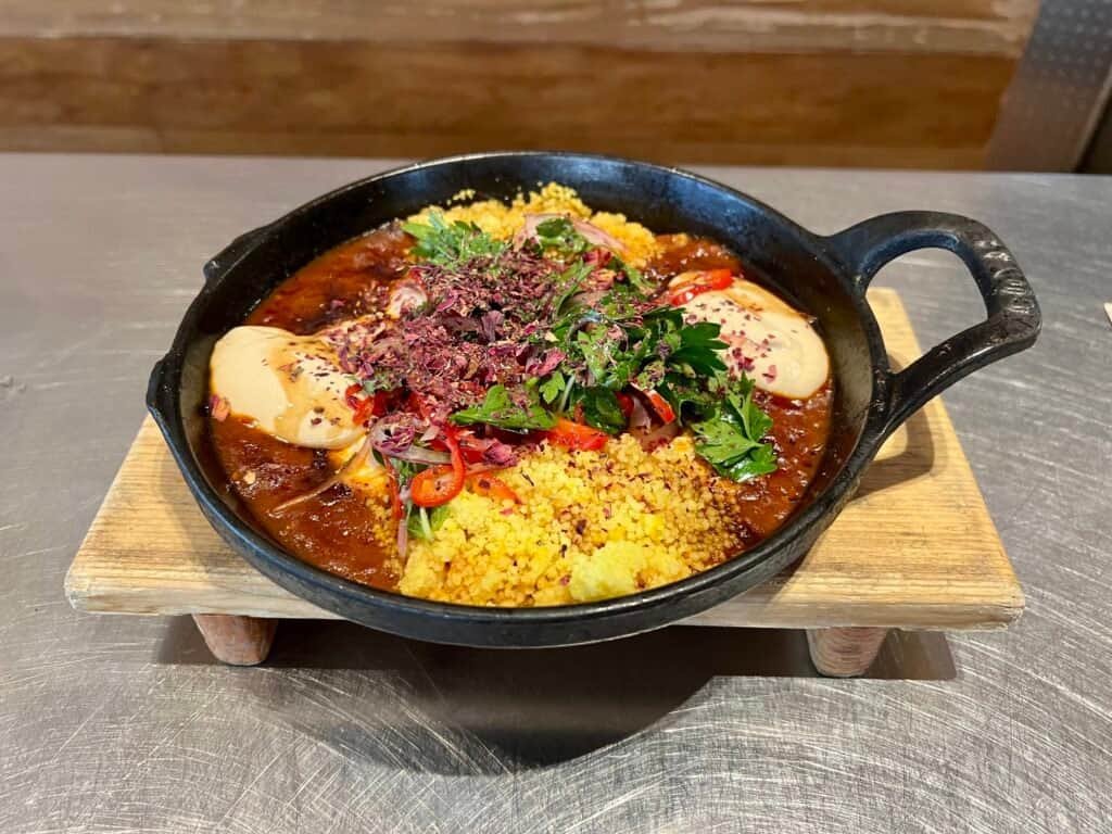 Spicy tomato shakshuka with eggs, herbs, and rich red sauce at avec in Chicago