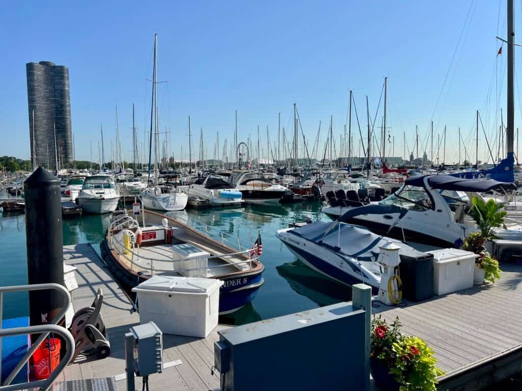 Boats docked at a Chicago marina with Lake Michigan and city buildings in the background